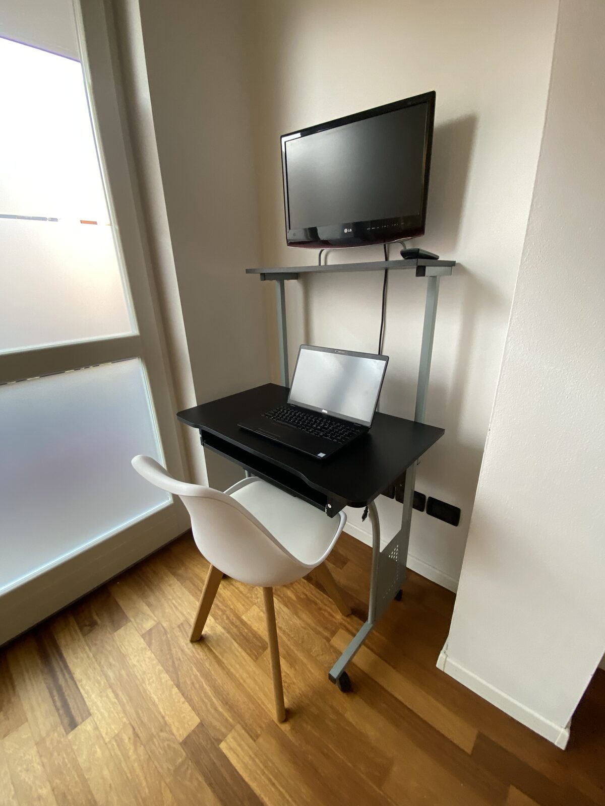 Postazione di lavoro con scrivania, monitor e laptop